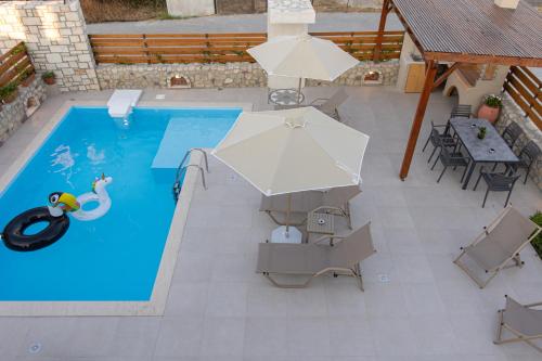 an overhead view of a swimming pool with an umbrella at Prinos Oasis Twin Villas III in Prínos