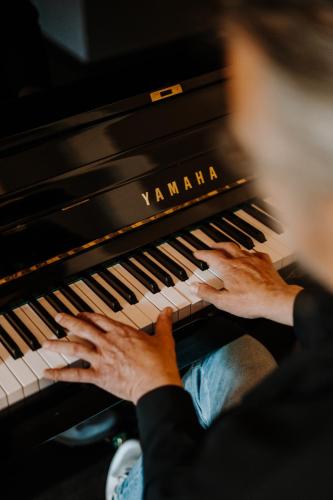 a person playing the keyboard of a piano at Parkhotel Mondschein, a Member of Design Hotels in Bolzano