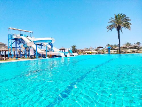 a pool with a water slide in a resort at Hotel Neptunia Skanes in Monastir