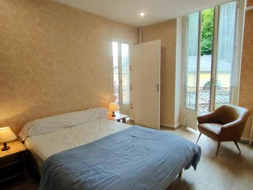 une chambre avec un lit, une chaise et une fenêtre dans l'établissement Appartement cosy avec balcon, proche thermes et télécabine, Cauterets - FR-1-234-135, à Cauterets