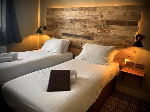 a hotel room with two beds with a laptop on the bed at Tyr Winch in Cardiff