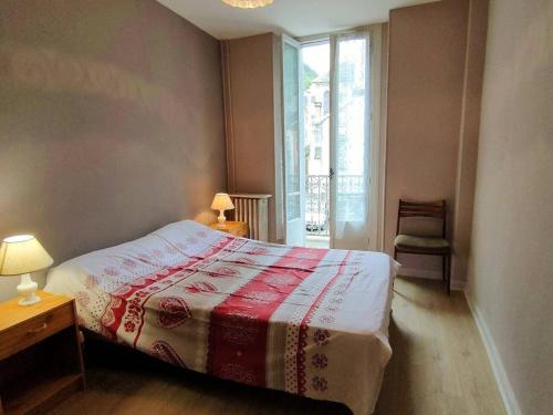 - une chambre dotée d'un lit avec une couverture rouge et blanche dans l'établissement Confortable T3 avec Balcon, Proche Thermes et Pistes - 6 Pers. - FR-1-234-142, à Cauterets