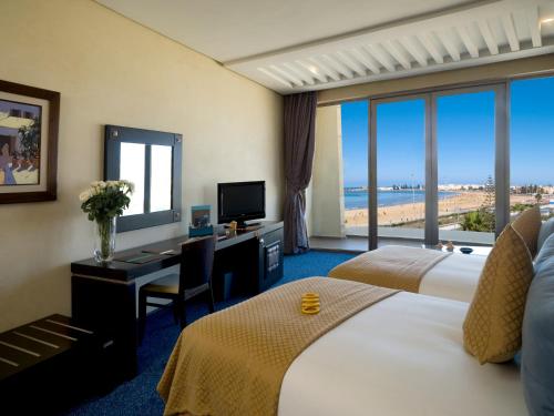 索維拉的住宿－Atlas Essaouira Riad Resort，酒店客房设有两张床和一张带电脑的书桌