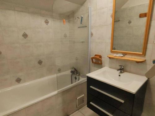 une salle de bain avec un lavabo, une baignoire et un miroir dans l'établissement Appartement 2bis pour 6 pers, proche télécabine, thermes, parking gratuit, orientation ouest - FR-1-234-247, à Cauterets