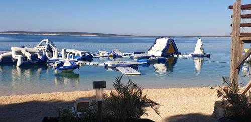 a water park with slides and boats in the water at Mobilna kućica Nika in Šimuni