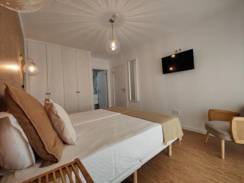 a bedroom with a large bed and a tv on the wall at Corkoon - Duna Parque Resorts & Hotels in Vila Nova de Milfontes