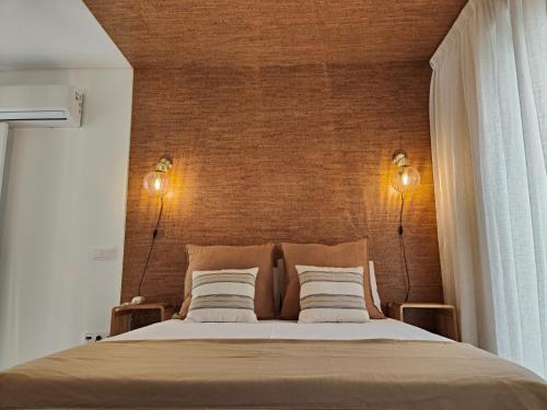 a bedroom with a large bed with two lamps at Corkoon - Duna Parque Resorts & Hotels in Vila Nova de Milfontes