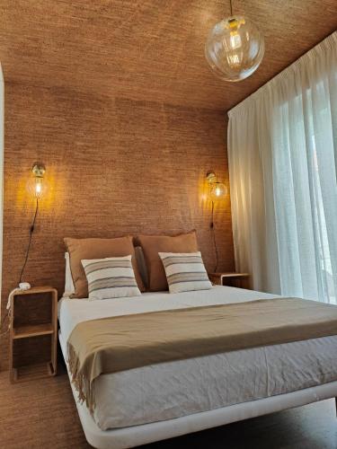 a bedroom with a large bed with two lights at Corkoon - Duna Parque Resorts & Hotels in Vila Nova de Milfontes