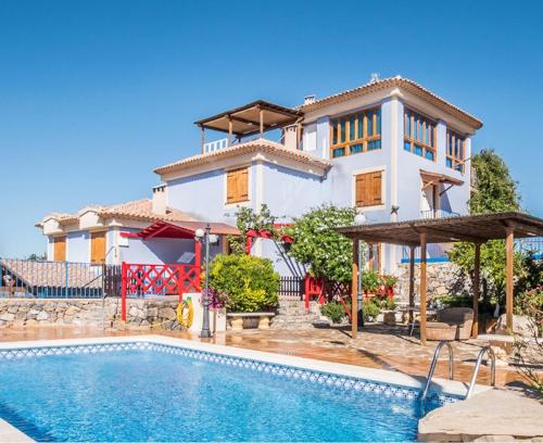 a villa with a swimming pool in front of a house at Casa Poniente - Casa Rural Los Cuatro Vientos in Moratalla