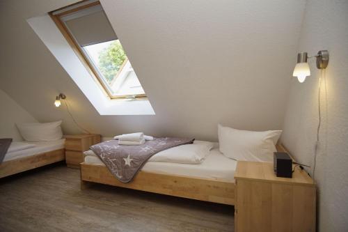 two beds in a room with a window at gemütliche Ferienwohnung in Hafennähe - FeWos am Hochzeitsberg FeWo 10 in Breege