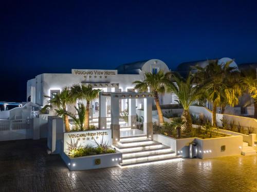 a white building with palm trees in front of it at Volcano View by Caldera Collection in Fira