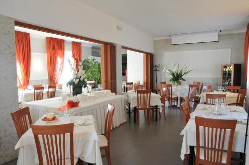 a restaurant with tables and chairs with white tablecloths at Hotel Mini Palace - Country House in Molinella
