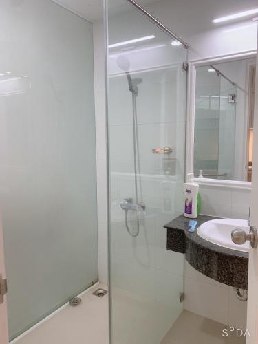 a bathroom with a glass shower and a sink at Comfortable Family Apartment at Sealinks Mui Ne in Ấp Ngọc Hải