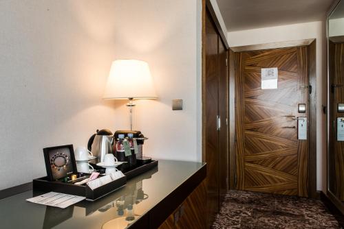 a hotel room with a desk with a lamp and a door at Kenzi Tower Hotel in Casablanca