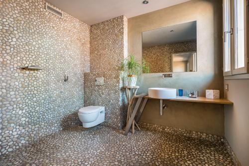ein Badezimmer mit einem WC, einem Waschbecken und einem Spiegel in der Unterkunft La Loge de mer, Lodge urbain in Perpignan