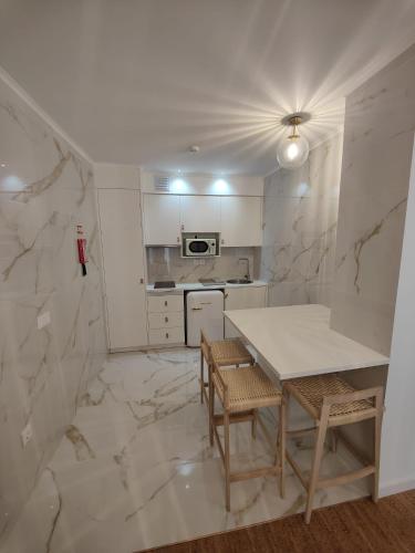 a kitchen with a table and two chairs and a counter at Corkoon - Duna Parque Resorts & Hotels in Vila Nova de Milfontes