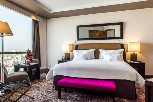 a bedroom with a large bed and a large window at Kenzi Tower Hotel in Casablanca