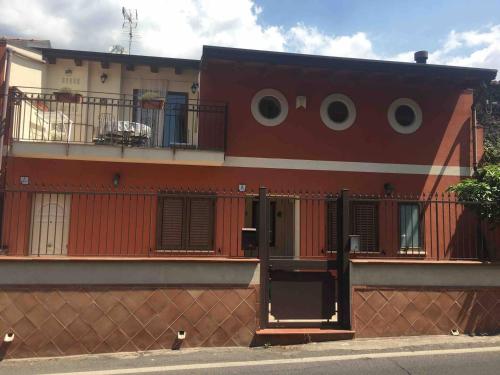 a red building with a fence in front of it at Stanza Luna in Ragalna