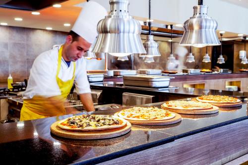 a chef preparing pizzas in a restaurant kitchen at Amadil Ocean Club in Agadir