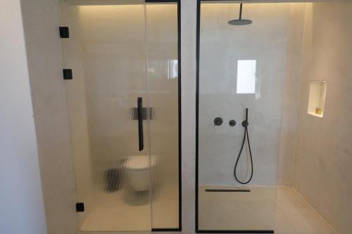 a glass shower with a toilet in a bathroom at Kalkan Han Hotel in Kalkan