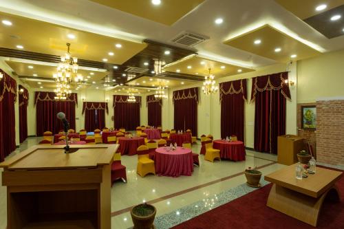 a banquet hall with tables and chairs and chandeliers at Hotel Ghyampe Dada in Bhaktapur