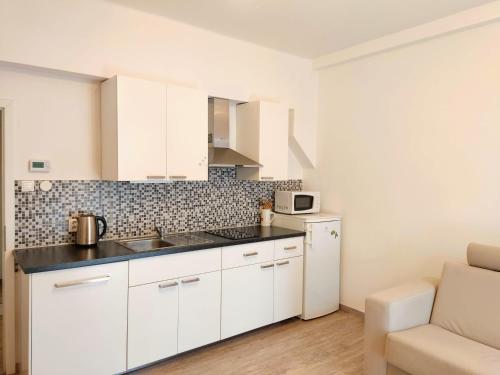 a kitchen with white cabinets and a white refrigerator at Apartment Žižkov in Prague