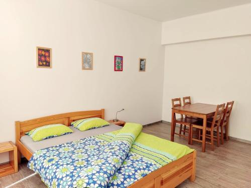 two beds in a room with a table and a desk at Apartment Žižkov in Prague