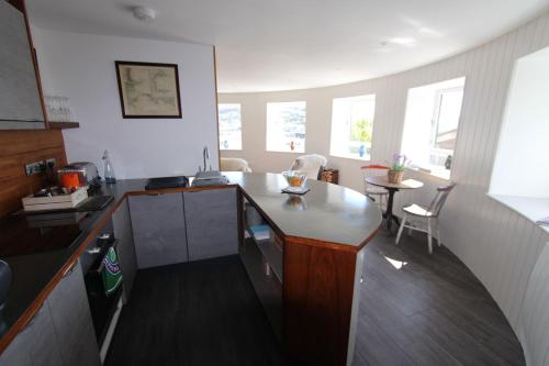 a kitchen with a counter and a table in a room at Admiral's Quarters - Stunning river and sea views in Dartmouth