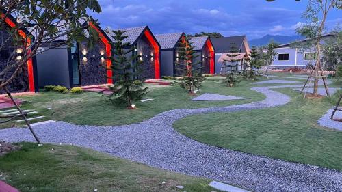 a garden with a gravel path in front of a house at ก๋างโต้ง คอฟฟี่รีสอร์ท in Ban Na Kham