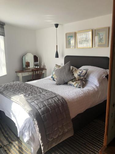 a bedroom with a large bed with pillows on it at Admiral's Quarters - Stunning river and sea views in Dartmouth
