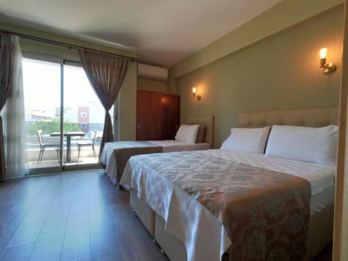 a hotel room with two beds and a balcony at Alâ Avsa Hotel in Avşa Adası