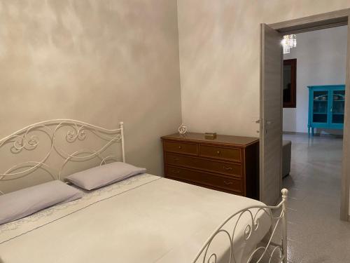 a bedroom with a white bed and a dresser at Coco' Country House Lecce in Lecce