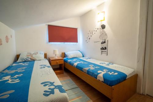 a bedroom with two beds and a red board at Apartman Mira in Vir