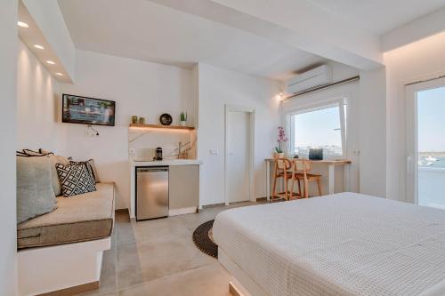 a bedroom with a bed and a couch and a kitchen at Nautica Suites - Modern Seaview Suite in Antiparos Town