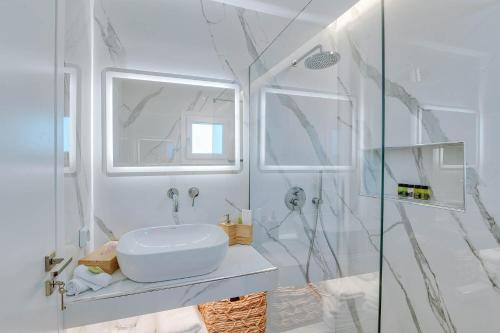 a white bathroom with a sink and a shower at Nautica Suites - Modern Seaview Suite in Antiparos Town