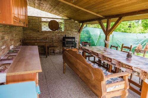 Szívem Csücske Vendégház في ناجيبورزسوني: غرفة بطاولات وكراسي خشبية وموقد