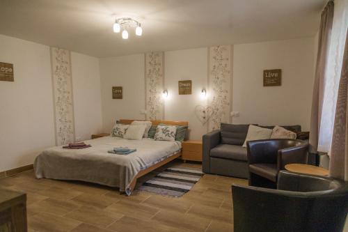 a bedroom with a bed and a couch at Szívem Csücske Vendégház in Nagybörzsöny