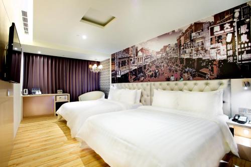two beds in a hotel room with a wall mural at FX Hotel Tainan in Tainan
