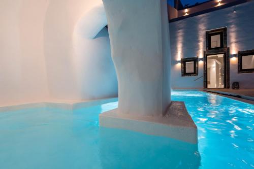 a swimming pool with a column in a building at Alme Luxury Cave Villas in Vóthon