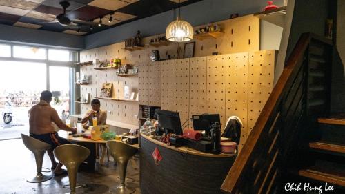 a man and a woman at a counter in a restaurant at 綠蠵龜潛水住宿 in Xiaoliuqiu