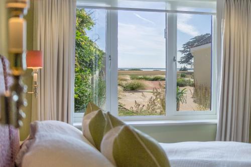 a bedroom with a window looking out at the beach at Marsh View in Aldeburgh