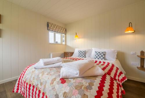 Snow Hall Barn في Peasenhall: غرفة نوم عليها سرير وفوط