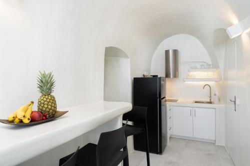 a kitchen with a plate of fruit on a counter at Alme Luxury Cave Villas in Vóthon