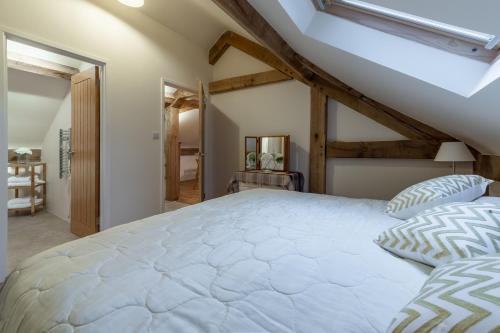 ein Schlafzimmer mit einem großen weißen Bett im Dachgeschoss in der Unterkunft Woodland Retreat Lodge in Brundish