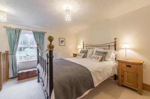 a bedroom with a large bed and a window at Flint Cottage in Wenhaston