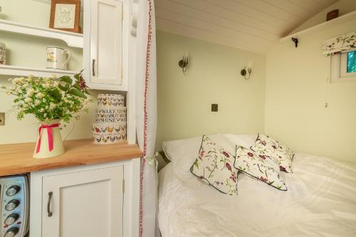 a small bedroom with a bed in a tiny house at Woodland Retreat Shepherd's Hut in Brundish