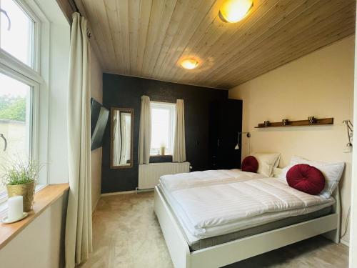 una camera da letto con un grande letto bianco con cuscini rossi di aday - Private room - Frederikshavn Center a Frederikshavn