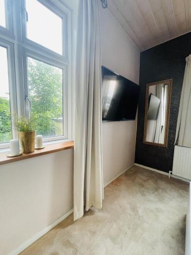 a living room with a window and a mirror at aday - Private room - Frederikshavn Center in Frederikshavn