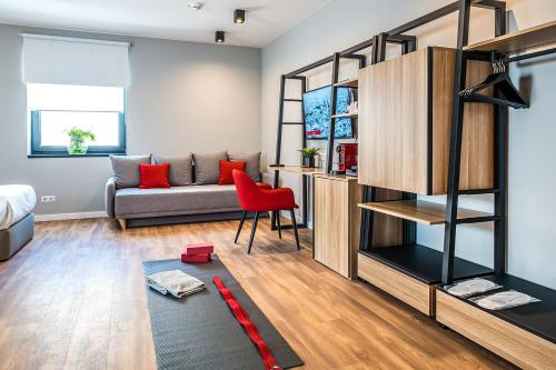a living room with a couch and a red chair at Up Hotel Budapest in Budapest
