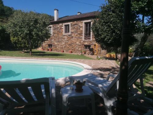 a house and a swimming pool in front of a house at Casa do Adro-Passadiços do Paiva Arouca in Arouca